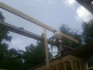 Carpenter setting a ridge beam over a new addition frame — Ice Dam Removal by Roofing Brothers in Santee