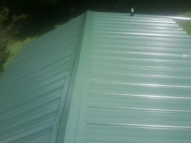 New green metal panels meeting at the ridge of a roof — Flat Roof Repair work by our crew in Santee